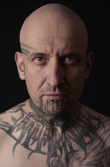 Portrait of Goorazz, a freehand gothic calligraphy and neotribal blackwork tattoo artist at Parliament Tattoo in London