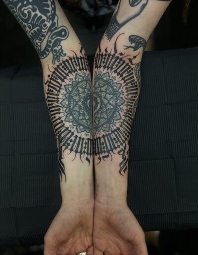 Symmetrical gothic abstract calligraphy mandala lettering tattoo on forearms by Goorazz, freehand tattoo artist at Parliament Tattoo in London